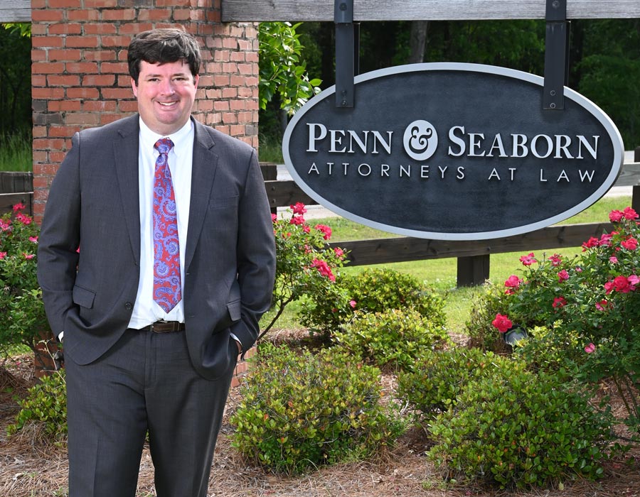 Attorney Charles Hudson Standing In Front Of Penn & Seaborn Sign Outside The Office