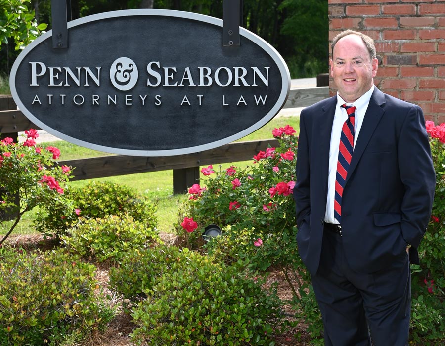 Attorney Will Partin Standing In Front Of Penn & Seaborn Sign Outside The Office